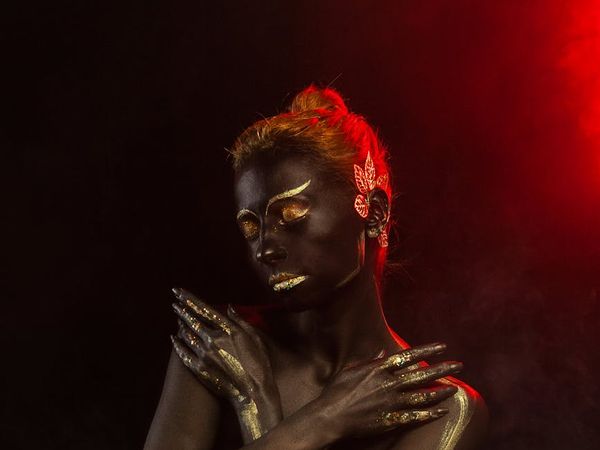 Person meditating in a dark studio with golden lighting accents